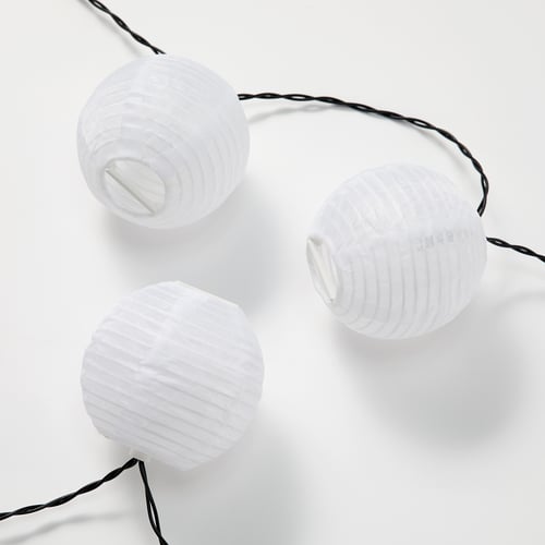 Trois lanternes blanches sont suspendues en ligne, créant une ambiance douce.