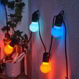 Guirlandes lumineuses intérieures/extérieures dans des tons chauds d’orange et de bleu froid.