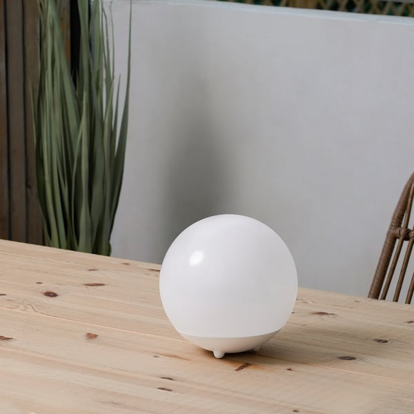 Lampe solaire SOLVINDEN sur table en bois avec plante.