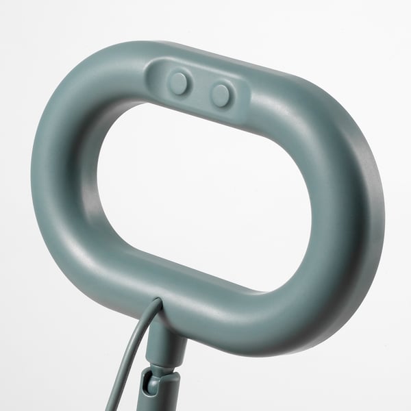Lampe annulaire compacte et élégante avec poignée souple, fixée par un câble soigneusement organisé, offrant un contrôle polyvalent de l’éclairage.