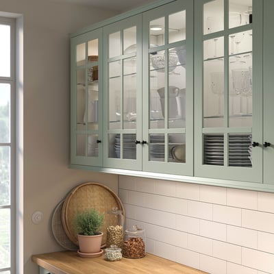 Armoires en verre vert avec verrerie, vaisselle et décoration.