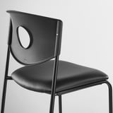 Chaise moderne noire au design élégant, cadre en métal et assise/dossier en plastique.