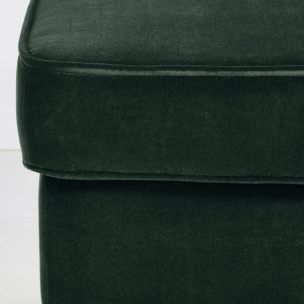 Gros plan sur une chaise en peluche vert foncé, mettant en valeur un tissu doux et luxueux.