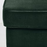 Gros plan sur une chaise en peluche vert foncé, mettant en valeur un tissu doux et luxueux.