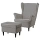 Un fauteuil à oreilles et un pouf STRANDMON en tissu pied-de-poule noir et blanc, offrant une disposition d’assise confortable et élégante.