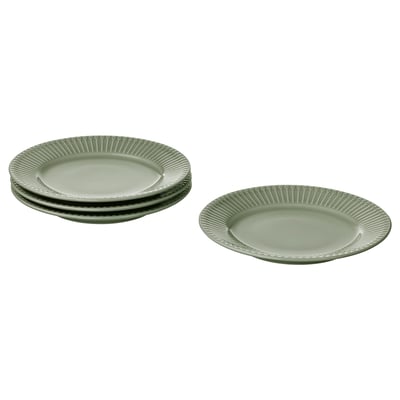 Quatre assiettes vert clair, trois empilées, une plate, bord texturé, céramique.