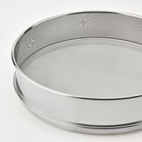 Gros plan d’un tamis rond et brillant en acier inoxydable avec des motifs de mailles complexes, mettant en valeur un savoir-faire de qualité.