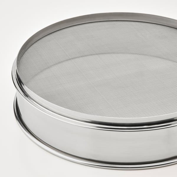 Tamis rond en métal à mailles fines, représenté à l’envers, sur fond blanc. Construction en acier inoxydable de haute qualité.
