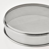 Tamis rond en métal à mailles fines, représenté à l’envers, sur fond blanc. Construction en acier inoxydable de haute qualité.