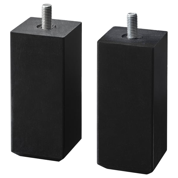 Deux pieds cubiques STUBBARP en bois noir avec vis métalliques sur le dessus, offrant un support réglable.