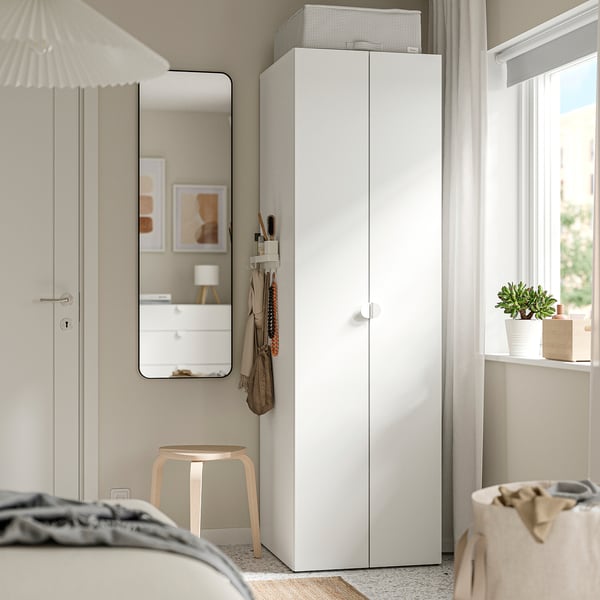 Pièce moderne avec un étui de rangement STUK blanc à côté du placard, sous la fenêtre, pour la plante.