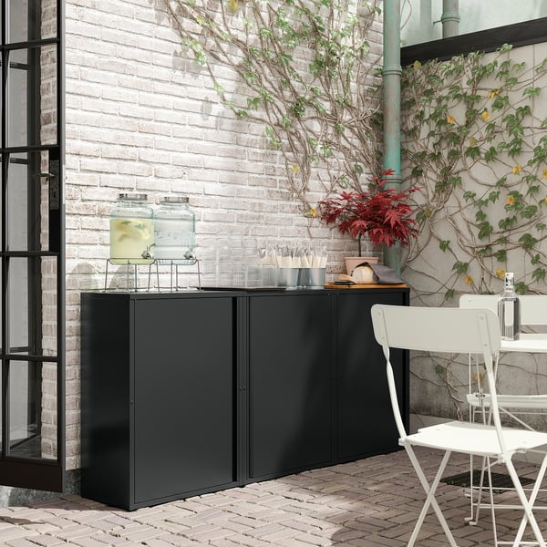 Armoire extérieure en métal noir avec plateau en verre et plantes. Parfait pour le rangement et la décoration.
