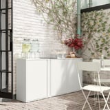 Installation extérieure moderne avec armoire SUNDSÖ blanche, mur de briques, plantes vertes et chaise blanche.