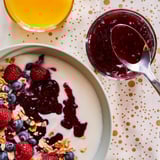 Parfait au yogourt avec granola, baies, confiture, cuillère, boisson aux agrumes.