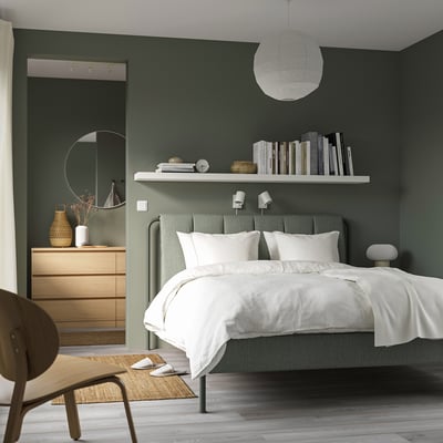 Chambre moderne avec lit TÄLLÅSEN, mur végétal, étagère, commode et chaise.