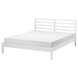 Un cadre de lit TARVA blanc au design simple et épuré. Il s’agit d’une tête de lit en métal avec des lattes horizontales et des pieds plats, soutenant un matelas de base.