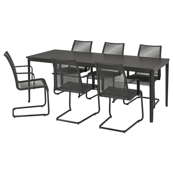 Ensemble de meubles d’extérieur noirs avec table rectangulaire et six chaises assorties, en métal et en plastique.
