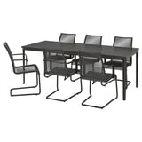 Ensemble de meubles d’extérieur noirs avec table rectangulaire et six chaises assorties, en métal et en plastique.