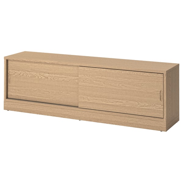 Un banc tv TONSTAD en placage de chêne avec portes coulissantes, conçu pour la gestion des câbles et des étagères réglables.