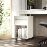 Petit meuble de rangement blanc avec tiroir, étagère, livres, bureau, fenêtre.