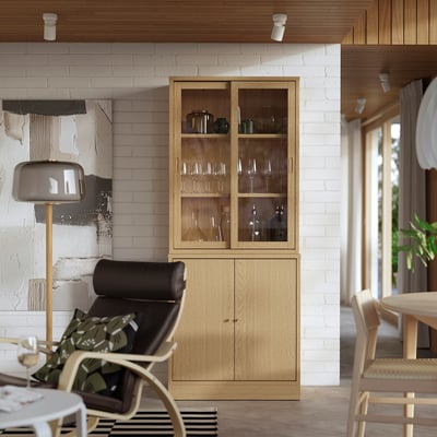 Salon moderne avec meuble en chêne TONSTAD, présentoir à vin et fauteuil en cuir. Style scandinave avec un espace confortable et organisé.