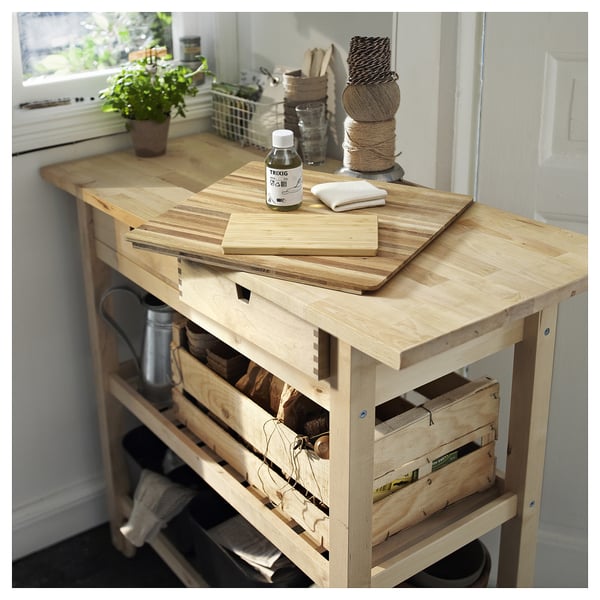 Chariot de cuisine en bois avec planches à découper, huile végétale et caisses en bois.