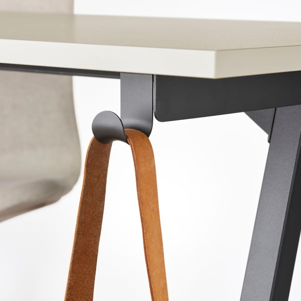 Bureau avec pieds en A pour plus d’espace. Sangle en cuir attachée à un crochet.