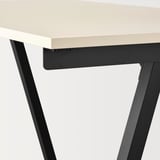 Bureau minimaliste moderne avec plateau beige et pieds noirs.