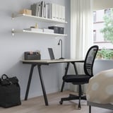 Bureau à domicile minimaliste moderne : bureau TROTTEN petit mais élégant avec chaise noire, ordinateur portable et étagères de rangement. Espace de travail soigné et efficace.