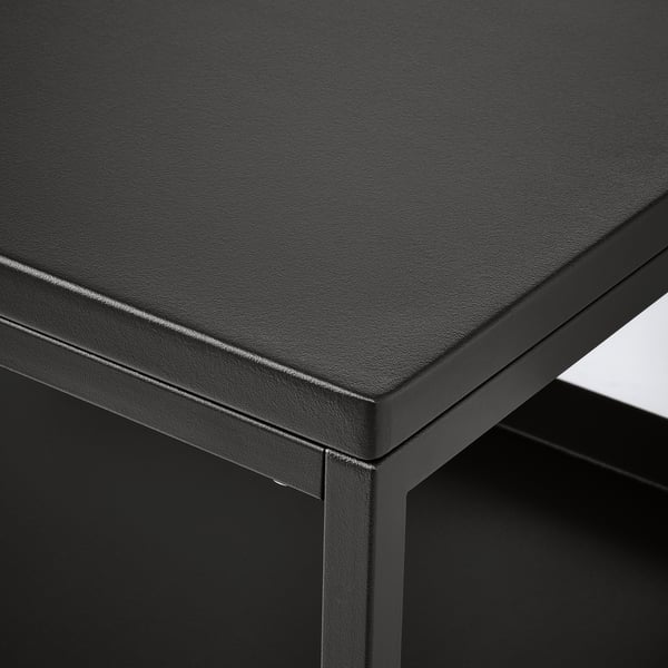 Table en métal thermolaqué noir avec des bords arrondis et élégants et une surface lisse, mettant en valeur un savoir-faire de haute qualité.