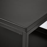 Table en métal thermolaqué noir avec des bords arrondis et élégants et une surface lisse, mettant en valeur un savoir-faire de haute qualité.