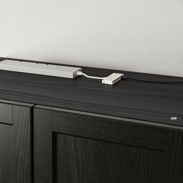 Chariot double prise de courant : sur une armoire en bois foncé, il ajoute 2 prises accessibles et 1 port USB pour charger plusieurs appareils.