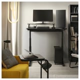 Bureau à domicile avec bureau de jeu, ordinateur, moniteur et canapé.