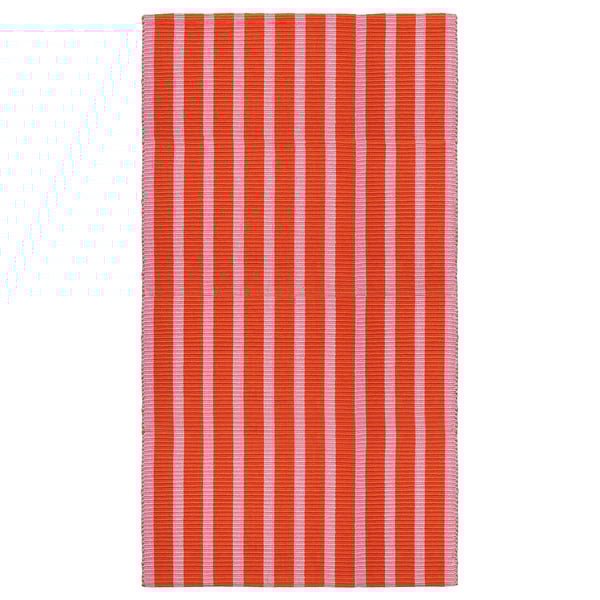 Un tapis rectangulaire nommé VÄGSKYLT avec des rayures verticales roses et oranges, en coton.