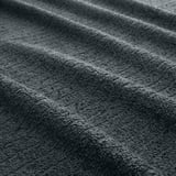 Gros plan de serviettes gris foncé, tissu éponge doux et texturé.