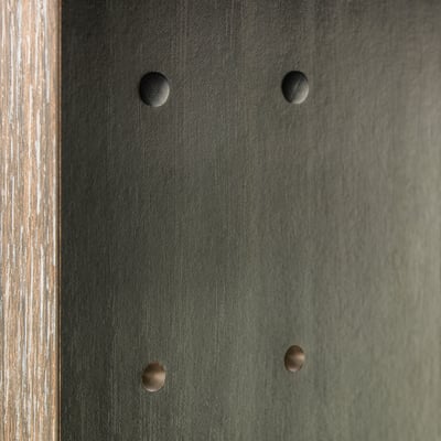 Quatre capuchons circulaires recouvrent les trous de perçage dans une surface sombre, ce qui les rend moins visibles et donne un aspect fini.