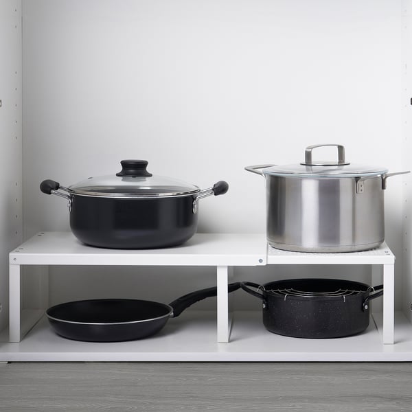 Deux inserts d’étagères : l’un avec des ustensiles de cuisine noirs, l’autre avec des casseroles grandes/petites.
