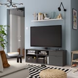 Salon moderne avec banc TV VIHALS, télévision à écran plat, tapis rayé, canapé blanc et applique murale. Style minimaliste.