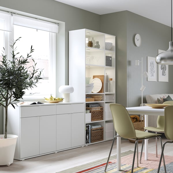Cuisine moderne avec rangement VIHALS blanc, chaises vertes, table à manger et grande fenêtre.