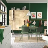 Cuisine moderne avec table à manger et chaises vertes VIHALS ; Armoires en bois, stylisées avec des plantes et des décors.