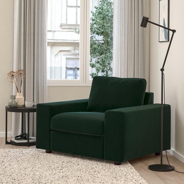 Salon moderne avec chaise VIMLE verte, lampe et table. Grande fenêtre et rideaux en arrière-plan.