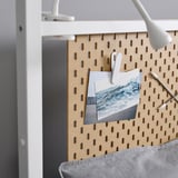 Panneau perforé avec des pinces blanches contenant une photo, mettant en valeur une solution de stockage et d’affichage de qualité.