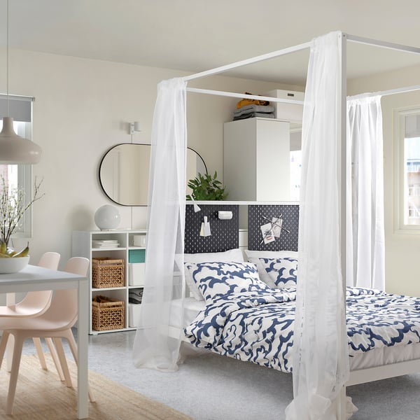 Studio moderne avec lit VITARNA, literie bleue, bureau, chaises roses.