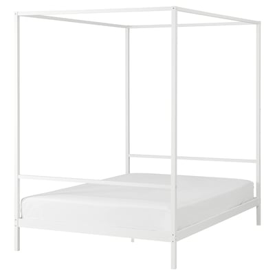 Un lit à baldaquin VITARNA blanc avec un cadre en métal. Il est minimaliste et moderne, idéal pour les petits espaces.