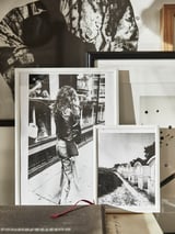 Des photos en noir et blanc sont présentées dans des cadres en plastique écologiques à enclencher, adossées à un mur. Les cadres contiennent diverses images vintage et artistiques.