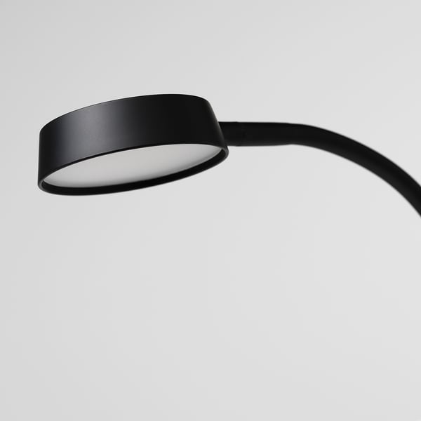 Lampe noire moderne avec bras flexible, émettant une douce lueur. Parfait pour les espaces limités, se pencher et pêcher au besoin.