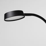 Lampe noire moderne avec bras flexible, émettant une douce lueur. Parfait pour les espaces limités, se pencher et pêcher au besoin.