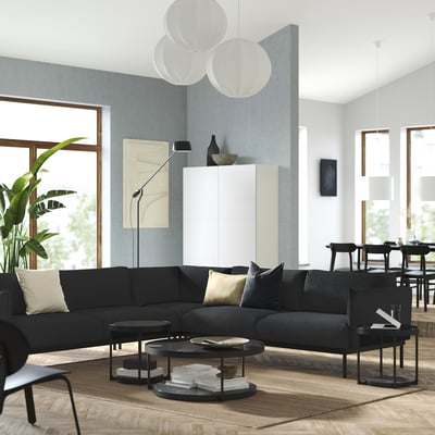 Moderne woonkamer met antracietgrijze ÄPPLARYD sectionele bank, zwarte salontafels en grote ramen.