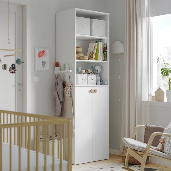 Kinderkamer met opbergruimte en wieg, perfect voor babybenodigdheden.