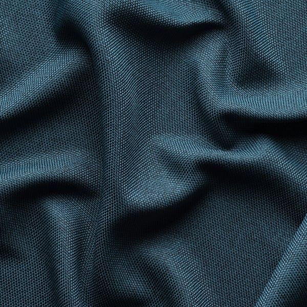 Close-up van donkerblauwe kamerverduisterende gordijnen, getextureerd met lichte plooien, met lichtblokkerende stof.